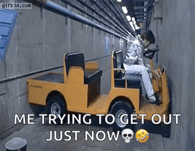 A Man Is Sitting In A Small Yellow Car In A Tunnel . GIF