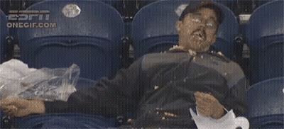 A Man Is Sitting In A Stadium With His Face Covered In Food And A Bag Of Trash . GIF