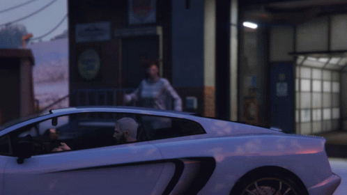 A Man Is Sitting In A White Sports Car While A Woman Stands In The Background GIF