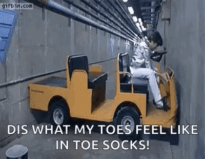 A Man Is Sitting In A Yellow Golf Cart . GIF