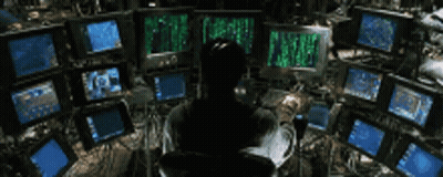 A Man Is Sitting In Front Of A Bunch Of Computer Monitors With The Word Matrix On The Screens GIF