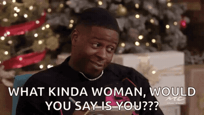 A Man Is Sitting In Front Of A Christmas Tree And Talking To Another Man . GIF