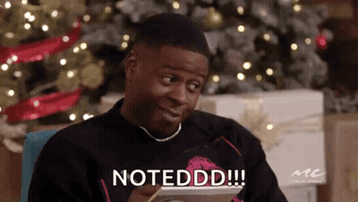 A Man Is Sitting In Front Of A Christmas Tree Holding A Tablet And Says Notedd . GIF
