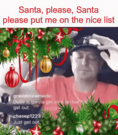 A Man Is Sitting In Front Of A Christmas Tree With A Person Putting A Hat On His Head . GIF
