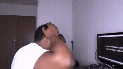 A Man Is Sitting In Front Of A Computer Screen Covering His Face With His Hand . GIF