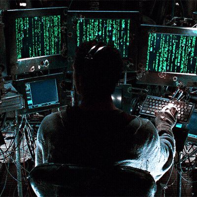 A Man Is Sitting In Front Of A Computer Screen That Says " Matrix " On It GIF