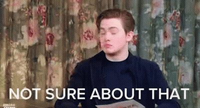 A Man Is Sitting In Front Of A Curtain And Holding A Piece Of Paper With The Words `` Not Sure About That '' . GIF