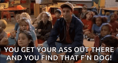 A Man Is Sitting In Front Of A Group Of Children In A Classroom And Talking To Them . GIF