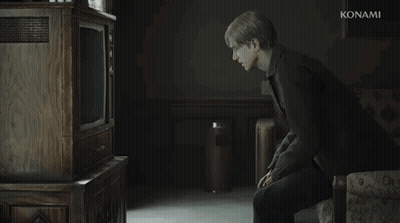 A Man Is Sitting In Front Of A Konami Television In A Dark Room GIF