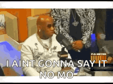 A Man Is Sitting In Front Of A Microphone And Saying I Ain T Gonna Say It No Mo . GIF