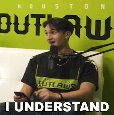 A Man Is Sitting In Front Of A Microphone While Holding A Cell Phone And Saying `` I Understand '' . GIF