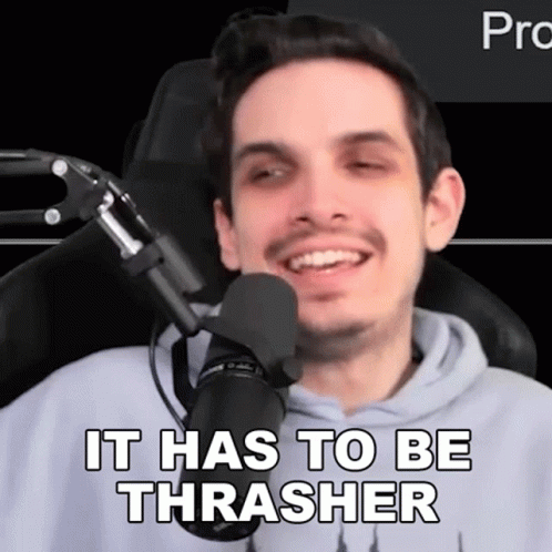 A Man Is Sitting In Front Of A Microphone With The Words It Has To Be Thrasher Written On His Face . GIF