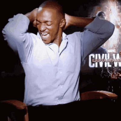 A Man Is Sitting In Front Of A Poster For Civil War GIF