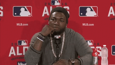 A Man Is Sitting In Front Of A Red Wall And Saying I 'M Ready GIF