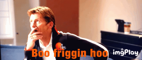 A Man Is Sitting In Front Of A Screen That Says Boo Friggin Hoo On It GIF
