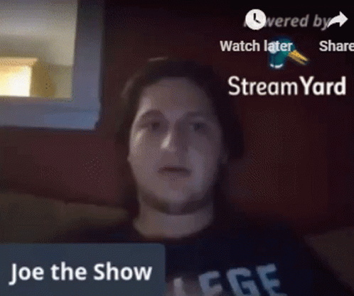 A Man Is Sitting In Front Of A Screen That Says " Joe The Show " GIF