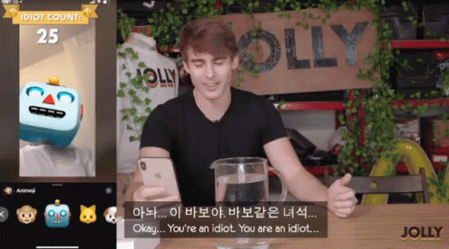 A Man Is Sitting In Front Of A Sign That Has The Word Jolly On It GIF