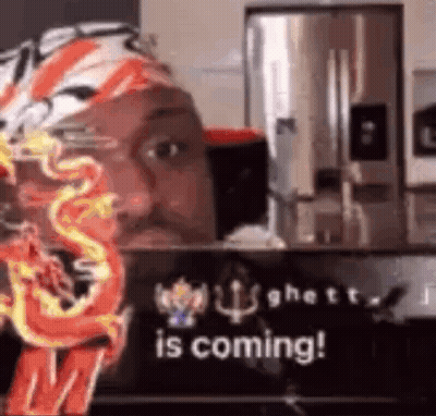 A Man Is Sitting In Front Of A Sign That Says `` Is Coming ! '' GIF