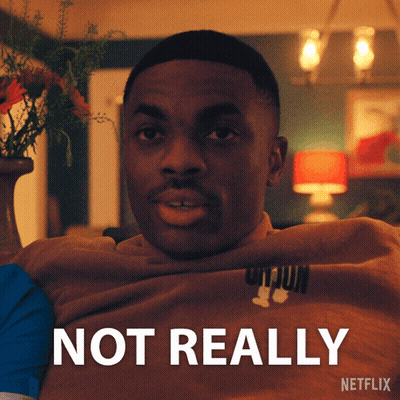 A Man Is Sitting In Front Of A Sign That Says Netflix GIF