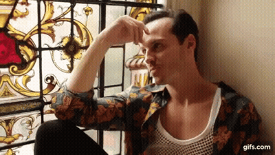 A Man Is Sitting In Front Of A Stained Glass Window And Looking Out . GIF