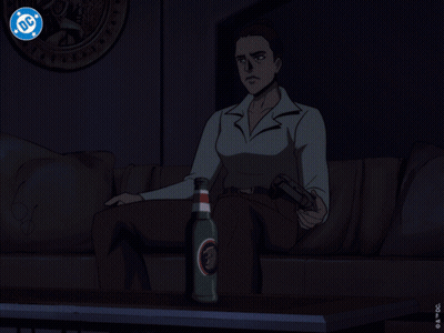A Man Is Sitting In Front Of A Television With A Dc Logo On The Screen GIF