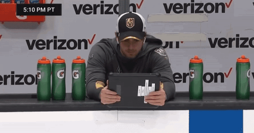 A Man Is Sitting In Front Of A Verizon Sign GIF