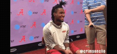 A Man Is Sitting In Front Of A Wall That Says At & T GIF