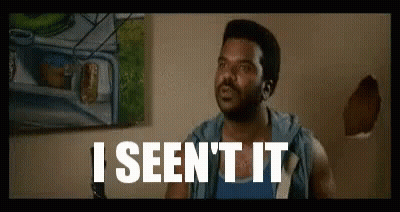 A Man Is Sitting In Front Of A Wall With A Painting On It And The Words `` I Seen It '' Written On It . GIF