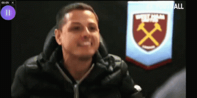 A Man Is Sitting In Front Of A West Ham Badge GIF