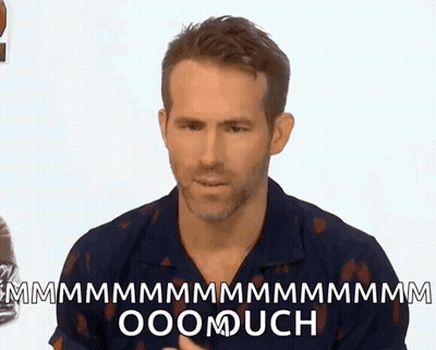 A Man Is Sitting In Front Of A White Wall And Making A Funny Face While Talking To Someone . GIF