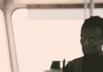 A Man Is Sitting In Front Of A Window On A Bus And Looking Out The Window . GIF