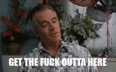 A Man Is Sitting In Front Of A Window With Balloons And Flowers In A Room . GIF