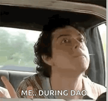 A Man Is Sitting In The Back Seat Of A Car And Looking Up . GIF