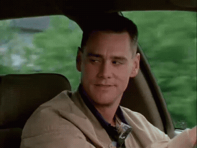 A Man Is Sitting In The Back Seat Of A Car Looking Out The Window . GIF