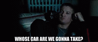 A Man Is Sitting In The Back Seat Of A Car Talking To Another Man . GIF