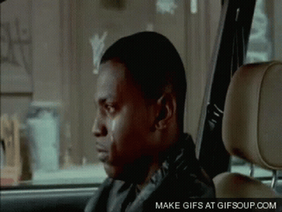 A Man Is Sitting In The Back Seat Of A Car With His Eyes Closed . GIF