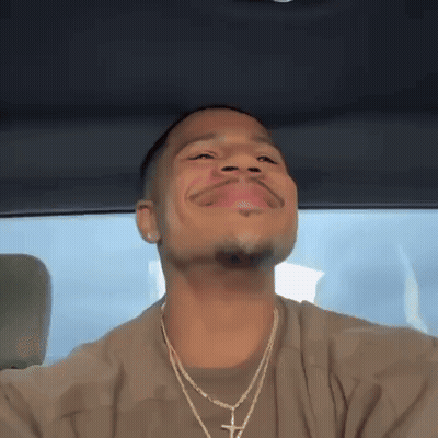 A Man Is Sitting In The Back Seat Of A Car With His Eyes Closed And His Mouth Open . GIF