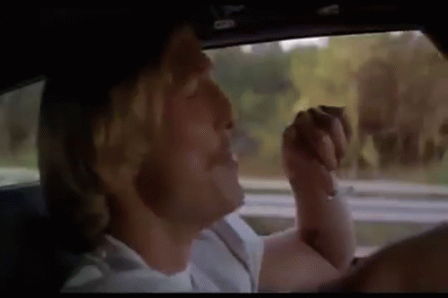 A Man Is Sitting In The Driver 'S Seat Of A Car . GIF