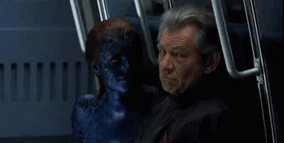 A Man Is Sitting Next To A Blue Monster With A Smile On His Face GIF