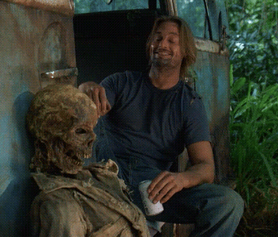 A Man Is Sitting Next To A Skeleton And Holding A Can Of Beer GIF