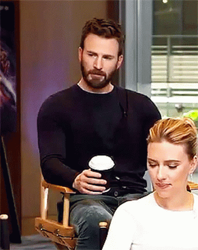 A Man Is Sitting Next To A Woman Holding A Cup Of Coffee GIF