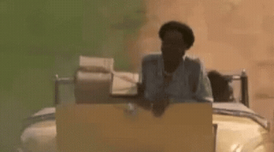 A Man Is Sitting On A Bed In A Car . GIF