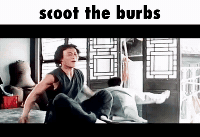 A Man Is Sitting On A Bed In A Room With The Words Scoot The Burbs Written Above Him . GIF