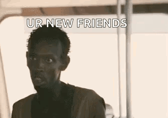 A Man Is Sitting On A Boat With The Words `` Ur New Friends '' Written On The Screen . GIF