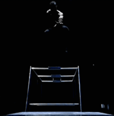A Man Is Sitting On A Chair In The Dark With His Legs Crossed GIF