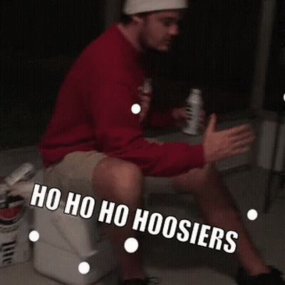 A Man Is Sitting On A Cooler With The Words Ho Ho Ho Hoosier Written On His Leg GIF
