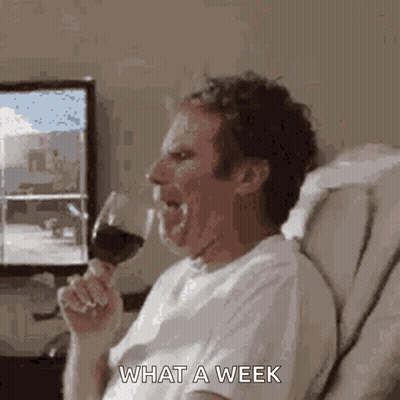 A Man Is Sitting On A Couch Drinking A Glass Of Wine And Making A Funny Face . GIF