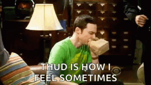 A Man Is Sitting On A Couch Eating A Sandwich From A Paper Bag . GIF