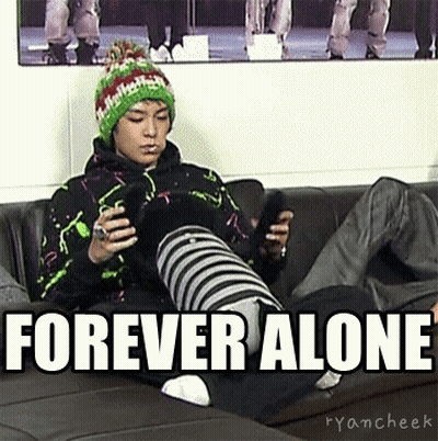 A Man Is Sitting On A Couch Holding A Cell Phone With The Words Forever Alone Above Him . GIF