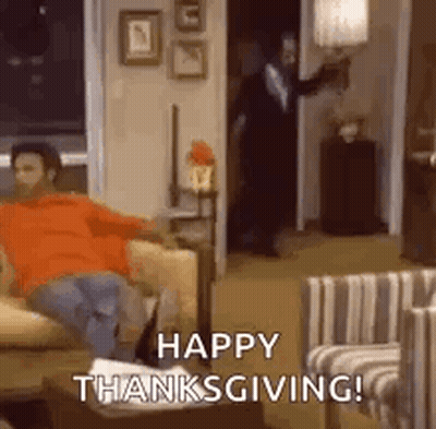 A Man Is Sitting On A Couch In A Living Room With The Words `` Happy Thanksgiving ! '' GIF